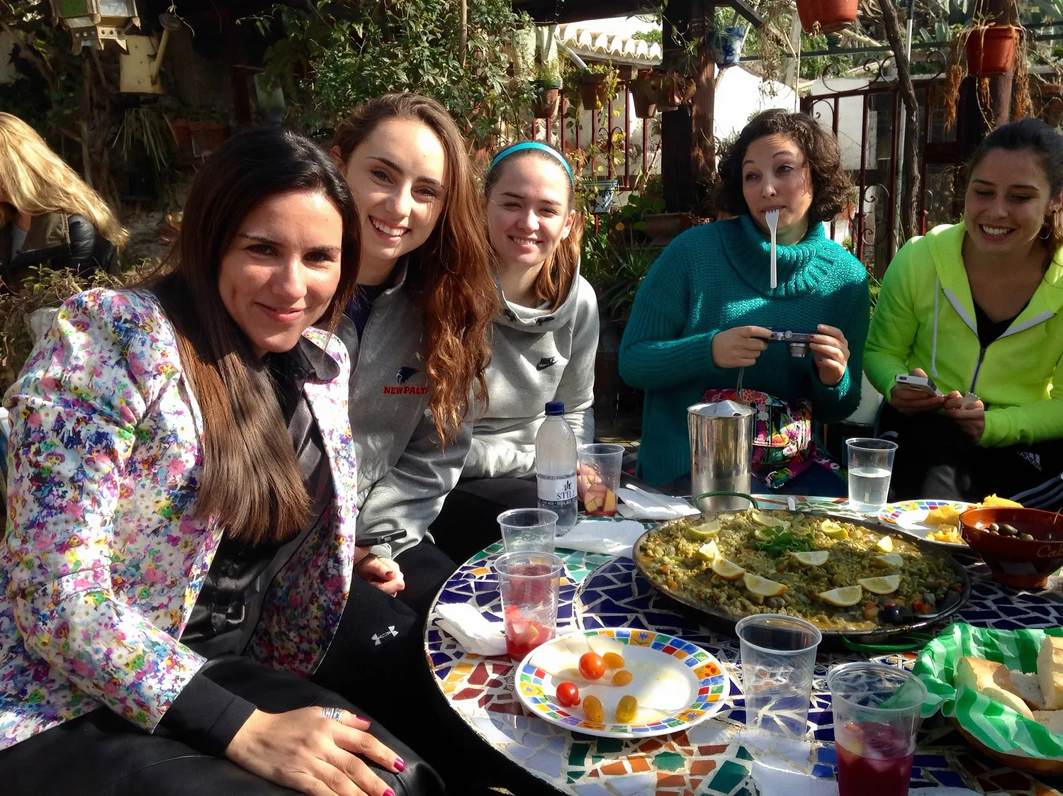 Patrícia à mesa com estudantes de intercâmbio em Granada, com uma paella ao centro