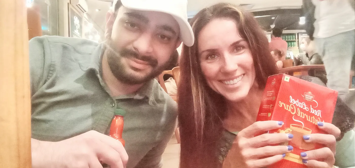 Patrícia e um aluno estrangeiro sorrindo em um café